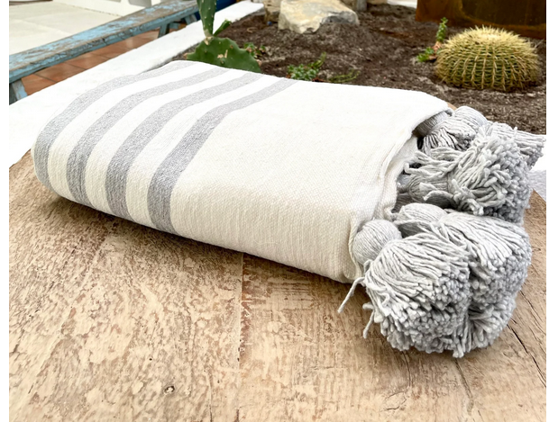 Plaid marocain à pompons assorti à une décoration en artisanat marocain