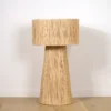 Lampe en raphia naturel, fabriquée par des artisans marocains, créant une ambiance douce et tamisée.