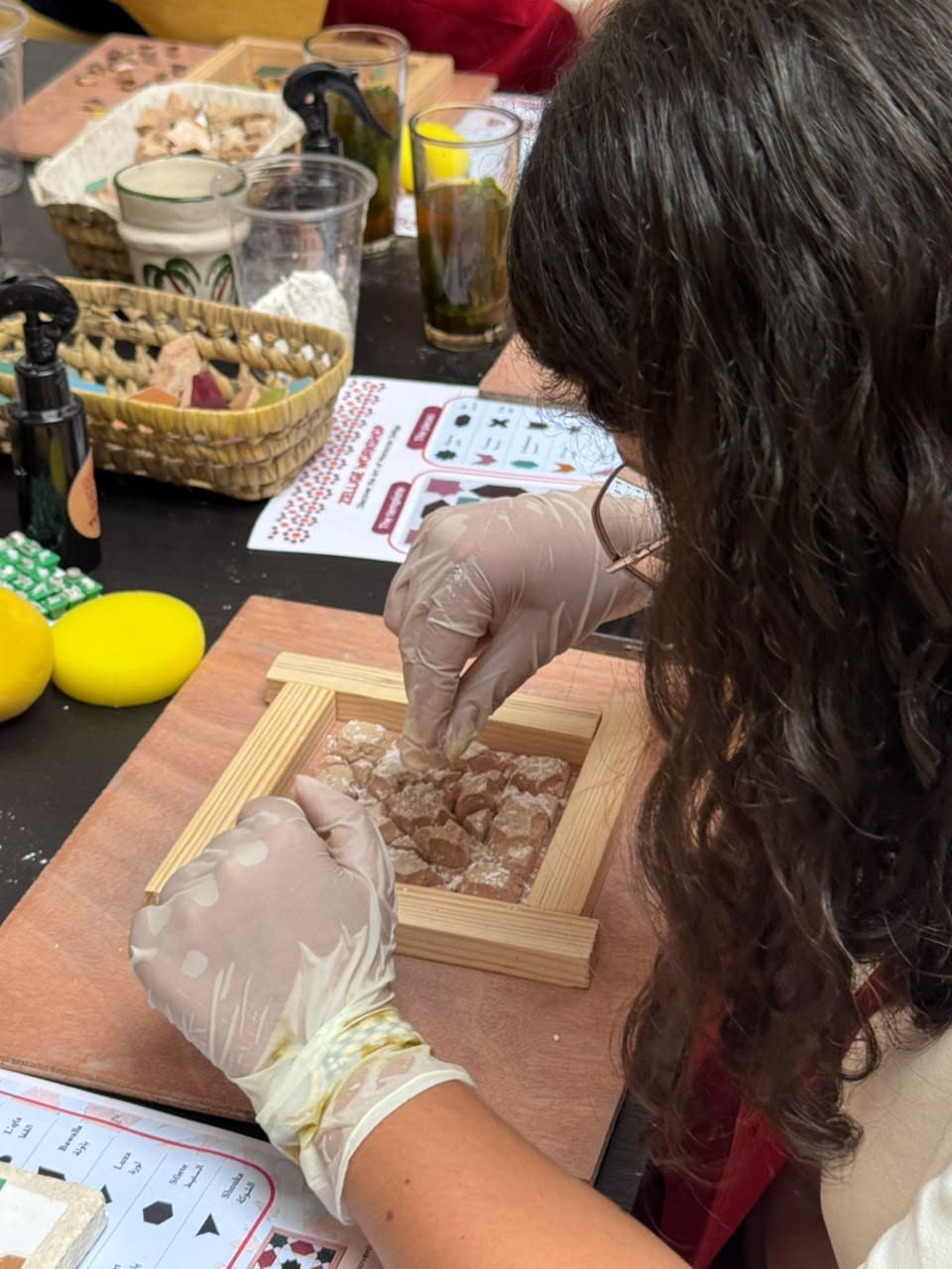 Participante composant son motif de mosaïque zellige pendant l'atelier